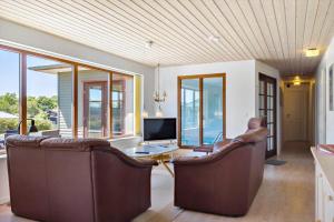a living room with two leather chairs and a television at LF11597-Struer-Plantagevej-97 in Struer