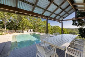 a patio with a table and chairs next to a swimming pool at The Farm on Razorback Ridge in Montville