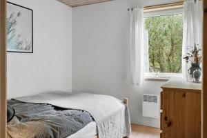 een witte slaapkamer met een bed en een raam bij LF10318-Hurup-Thy-Sortmejsevej-2 in Sønder Ydby