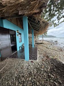 a building with a straw roof on a beach at Blue Sky Resort in Ko Chang
