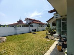 a backyard with a fence and a house at KLIA Guesthouse-3 bedroom 2 bathroom in Banting