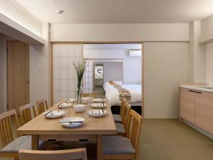 宮島にあるb hotel Miyajima Omotesando - Sacred Island Stay 22のダイニングルーム(テーブル付)、ベッドルーム1室