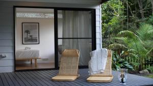 two wicker chairs sitting on the deck of a house at The One Pearl Beach- Pet Friendly, firepit, walk to beach in Pearl Beach