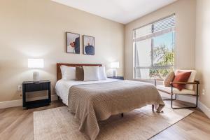 Un dormitorio con una cama y una ventana y una silla. en 2BD Marina Condo Near Venice Beach, Pool & Free Parking, en Los Ángeles 15 fotos más