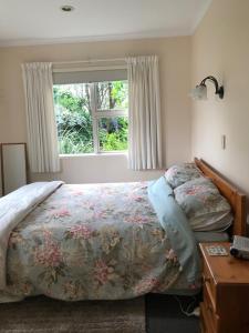 une chambre avec un lit et une fenêtre dans l'établissement The Cottage on Hurford - New Plymouth, à New Plymouth