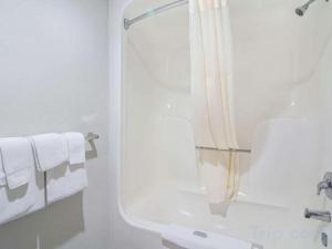 a bathroom with a shower and a sink with towels at Rodeway Inn Lumberton Central in Lumberton +58 photos
