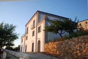 duży biały budynek z kamienną ścianą w obiekcie Villa Cirimarco w mieście Bonifati