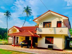 a house with a car parked in front of it at Surf Front in Ahangama