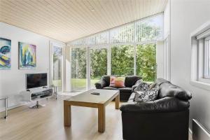 a living room with a leather couch and a table at LF530-Vestervig-Hannesvej-30 in Vestervig