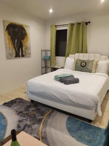 a bedroom with a large white bed and a window at Green Salad Hostel in Ban Thong Phlu