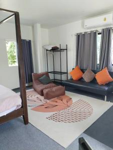 a living room with a bed and a couch at Green Salad Hostel in Ban Thong Phlu