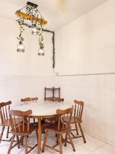 a table in a room with chairs and a white wall at Golden House 18 in Ipoh