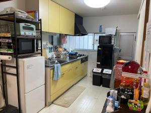 a kitchen with yellow cabinets and a counter top at SunHome コリアタウン近く 一軒家貸切り 今里 in Osaka