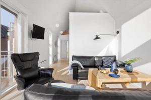 sala de estar con mesa y sillas de cuero negro en LF10214-Thyholm-Havnefronten-14, en Thyholm