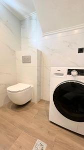 ein weißes Badezimmer mit Toilette und Mikrowelle in der Unterkunft Lemon Tree Studio 2 in Mytilini