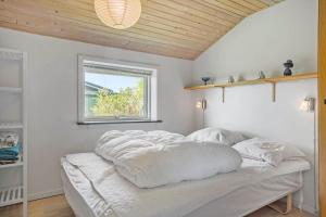 a bed with white sheets on it in a room with a window at LF320-Hurup-Thy-Skraningen-9 in Doverodde +19 photos