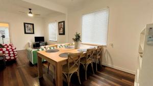 a dining room with a wooden table and chairs at Teke Cottage in Wooli