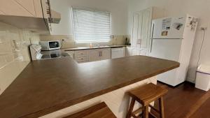 a kitchen with a large counter and a refrigerator at Teke Cottage in Wooli
