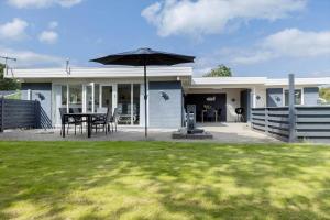 une maison avec une table et un parasol dans la cour dans l'établissement LF12708-vinderup-Solsortevej-8, à Vinderup