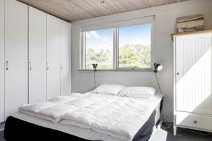 une chambre avec un grand lit blanc avec une fenêtre dans l'établissement LF12708-vinderup-Solsortevej-8, à Vinderup