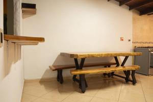 a table and a bench in a kitchen at Jungle House Medellin in Medellín +6 photos