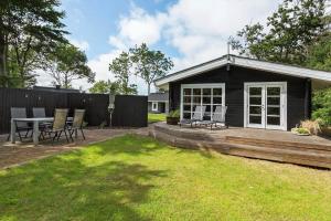 a house with a deck and a table and chairs at LF10999-Thyholm-Ringvejen-9 in Thyholm