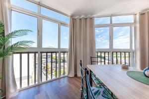 a dining room with a table and large windows at Apartamento Playa y Sol in Calpe