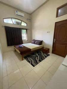 a bedroom with a bed and a window and a rug at Lanina homestay in Ipi