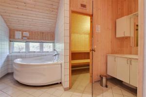 Un baño con una bañera grande y un lavabo. en 1441-Aakirkeby-Strandparken-14, en Vester Sømarken
