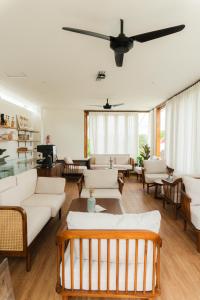 a living room with white furniture and a ceiling fan at Tannari Villa Ubud in Ubud