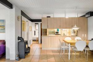 a kitchen and dining room with a table and a stove at 5577-Gudhjem-Norrelokke-18 in Gudhjem