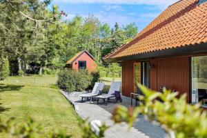 a patio with two chairs and a house at 5577-Gudhjem-Norrelokke-18 in Gudhjem