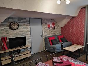 a living room with a couch and a tv at La cité des abeilles in Villemandeur