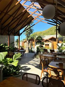 a patio with tables and chairs and a mountain at Batatu Resort - Adults Only in Kuta Lombok