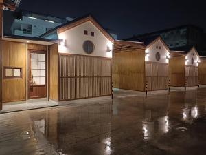 a row of wooden garages in a parking lot at night at SK Village in Ban Baen Phichit
