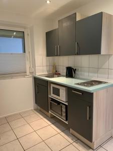 una cucina con piano di lavoro e forno a microonde di Tuvalu a Remagen