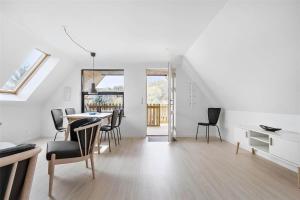 a white room with a dining table and chairs at 6784-Allinge-Nordre-Strandvej-127 in Allinge +11 photos