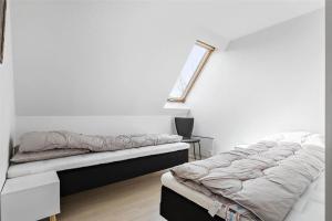 a white room with two beds and a window at 6784-Allinge-Nordre-Strandvej-127 in Allinge