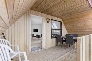 a room with a table and chairs on a wooden deck at 6784-Allinge-Nordre-Strandvej-127 in Allinge