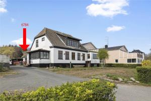 a house with a red arrow pointing at it at 6784-Allinge-Nordre-Strandvej-127 in Allinge