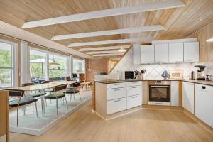 eine Küche mit weißen Schränken und einem Tisch mit Stühlen in der Unterkunft 1584 Aakirkeby - Poseregårdsvejen 16 in Vester Sømarken