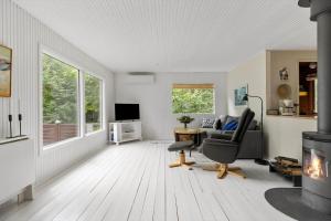 a living room with a fireplace and a chair at 2700-Nexo-Munkegardsskoven-3 in Neksø