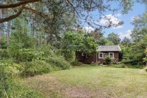 a small house in the woods with a yard at 2700-Nexo-Munkegardsskoven-3 in Neksø