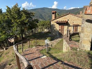 a stone house with a gate and a fence at Agriturismo Casa Paradiso in Cortona