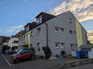 a red car parked in front of a building at Hotel Alscher in Leverkusen