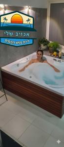 a woman is in a bathtub in a restaurant at דירת נופש באכזיב עם ג'קוזי מול חוף בננה ביץ Dream Place Achziv in Nahariyya