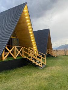 a house with a black roof with lights on it at Kolsay Aframe Vibes in Saty +8 photos