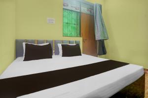 a bedroom with a large white bed with black pillows at Hotel O Tejaswi Hotel in Prayagraj +21 photos