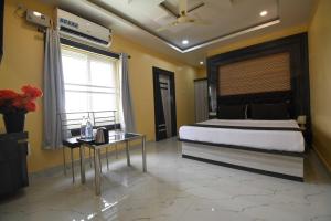 a bedroom with a large bed and a table at Hotel O Prince Residency in Bhubaneshwar