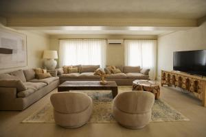 a living room with a couch and chairs and a tv at Mediterranean Seasons Sensation Villa in San Vicente del Raspeig